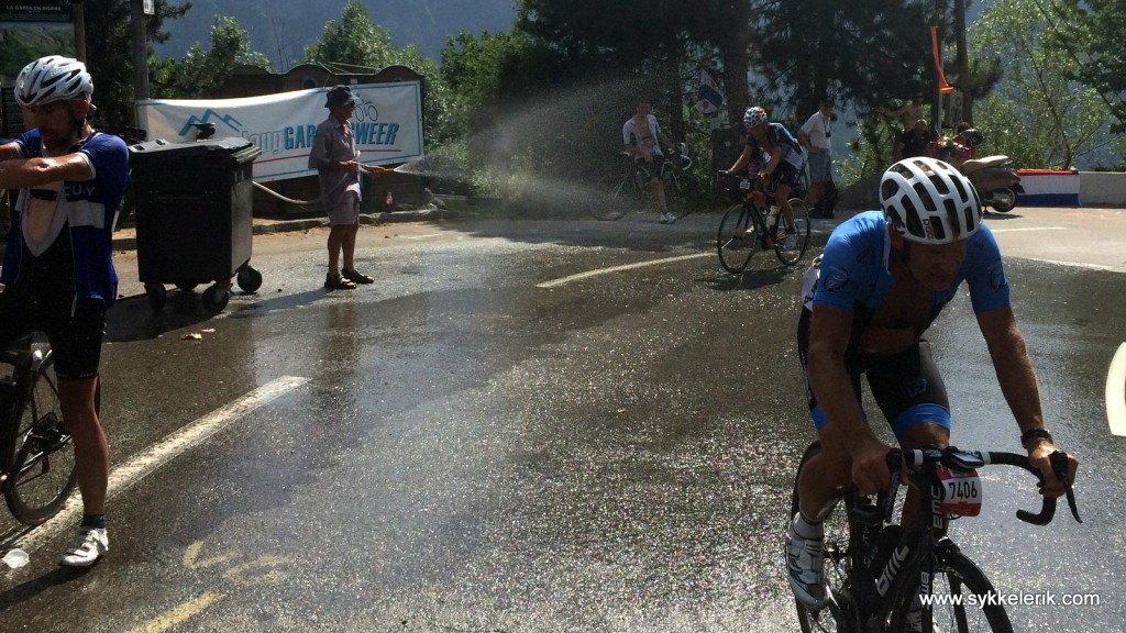 Ved La Garde - i sving 16, 10 km fra toppen av Alpe d'Huez - spyles syklister og forsynes med vann. 